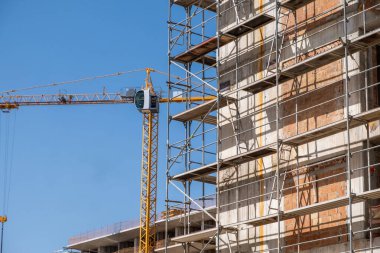 İnşaat alanı, iskele sistemi ve vinç, inşaat projesi altında, mavi gökyüzü