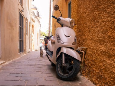 Girit adası Yunanistan 'daki Chania Old Town' da dar bir kaldırım taşı ara sokağına scooter moto park etti.