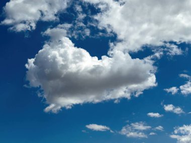 Bulutlu mavi gökyüzü, güneşli bir gün. Beyaz pofuduk bulutlar, doğa manzarası