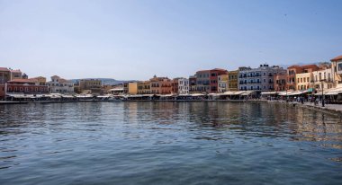 Chania eski kasaba manzarası. Eski Venedik limanındaki geleneksel rıhtım binaları ve dükkanlar, güneşli bir gün, mavi gökyüzü