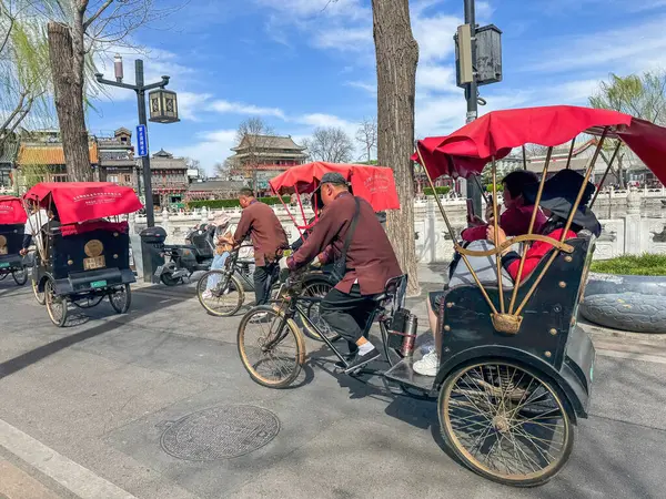 Pekin, Çin. 25 Mart 2025. Geleneksel bisiklet yarışları turistleri tarihi Shichahai, güneşli bahar gününde naklediyor.