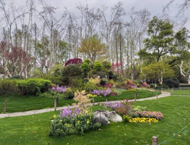 Topçu sanatı heykelleri, Batı Gölü bahçesi, Hangzhou, Çin. Nilüfer çiçekleri ve yapraklar şekilli heykeller, yemyeşil ağaçların yemyeşil arka planı.