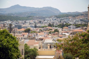 Rethymno şehri Girit Adası, Yunanistan. Döşeme çatılı geleneksel evler, modern apartmanlar ve çevre dağlarla çevrili.