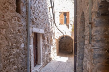 Mesta ortaçağ köyü. Chios Adası, Yunanistan. Dar kaldırım taşı sokağı, geleneksel mimari taş evler ve kemer. Kırsal ahşap kapılar ve pencereler