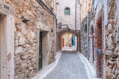 Olimpoi ortaçağ köyü, Chios Adası, Yunanistan. Geleneksel mimari. Dar sokak, taş duvarlar ve taş kemer..