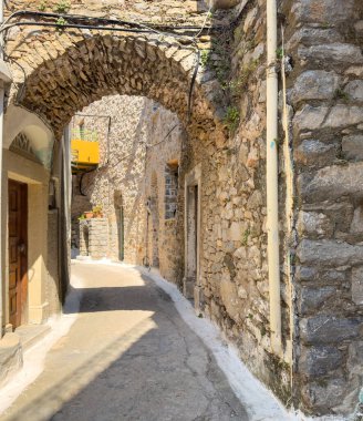 Olimpoi ortaçağ köyü, Chios Adası, Yunanistan. Geleneksel mimari. Dar sokak, taş duvarlar ve taş kemer..