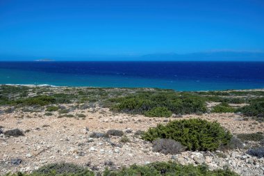 Gavdos Adası, Yunanistan. Tripiti Sahili. Kayalık sahil şeridi seyrek bitki örtüsü ve okyanus dalgaları mavi gökyüzü, yaz güneşli günü