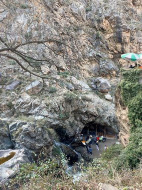 Setti Fatma, Morocco, March 5, 2023. Tourists at the rocky cave and small waterfall within the Atlas Mountains, rugged cliffs and sparse vegetation
