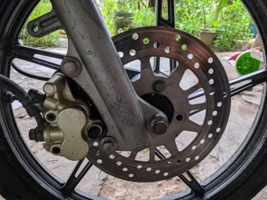 Motor atölyesine yeni monte edilmiş bir motosiklet fren diski ve beş jant teli olan spor çemberi..