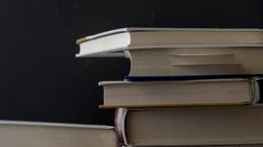 Koyu arkaplan üzerine eski kitap yığını