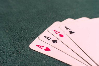 Yeşil kumaşın üzerindeki dört as.