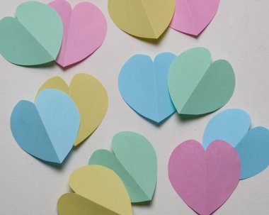 Beyaz arkaplanda pastel renkli kağıt kalpler