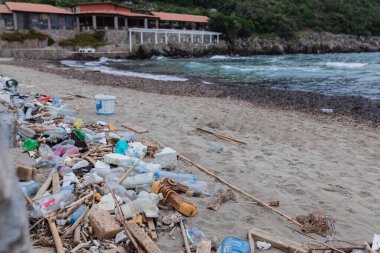 Karadağ 'da bir balıkçı köyünde kirlenmiş plaj, çevre kirliliği kavramı, Asya veya Avrupa