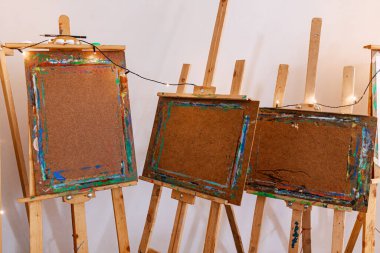 Yatay ve dikey ahşap sehpa tahtaları, parlak boya renkleriyle boyanmış. Dekoratif sicim lambaları ve görünür kalemler sanatsal işler için davetkar ve sıradan bir atmosferi çağrıştırıyor..