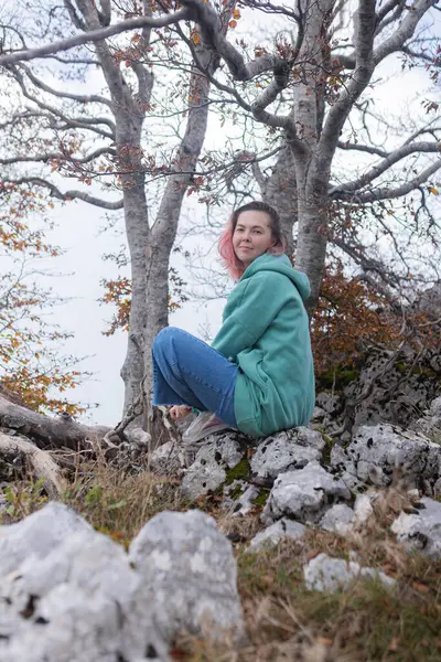 Çift, sonbahar yollarında dağdaki sislere bakıyor. Kol kola duran çift, sisli orman patikalarına, altın yapraklara, sise ve kayalık kenarlara bakıyor. Açık havada sakin bir atmosfer yaratıyor..