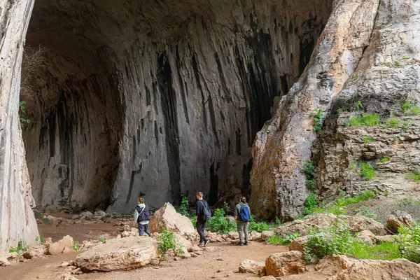 Turistler mağaraya yüksek kemerli tavan ve koyu mineral çizgileriyle çizgili dikey duvarlarla girerler. Büyük mağara, içeriyi keşfeden ziyaretçi gruplarıyla doludur. Kemerli kireçtaşı tavanı ve dikey erozyon lekeli dokulu duvarlar uzaya hükmediyor.
