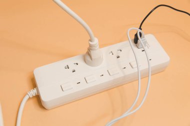 Evdeki prizin prizine elektrik prizi, evdeki prizin prizine elektrik prizi, enerji verimliliği konsepti, bej arka planda uzatma kablosu olan elektrik şeridi, üst görünüm..