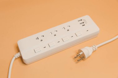 Evdeki prizin prizine elektrik prizi, evdeki prizin prizine elektrik prizi, enerji verimliliği konsepti, bej arka planda uzatma kablosu olan elektrik şeridi, üst görünüm..