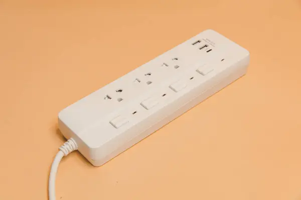 Stock image Electrical plug in outlet socket at home, Electrical plug in outlet socket at home, Energy efficiency concept, Power strip with extension cord on beige background, top view.