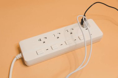 Evdeki prizin prizine elektrik prizi, evdeki prizin prizine elektrik prizi, enerji verimliliği konsepti, bej arka planda uzatma kablosu olan elektrik şeridi, üst görünüm..