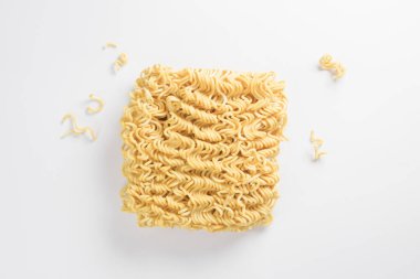 Etrafında hazır erişte parçaları olan pişmemiş hazır şehriyeler, beyaz arka planda kuru hazır şehriye dokusu.