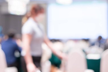 Ortam aydınlatmalarıyla dolu modern bir konferans salonunun bulanık görüntüsü