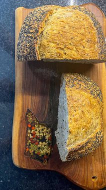 Dekoratif bir tepside ikiye bölünmüş çok tahıllı ekmek. 