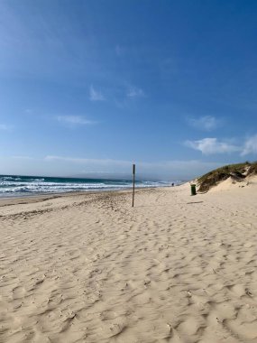 Lizbon, Portekiz 'de arka planda dalgaların çarptığı terk edilmiş bir plajın fotoğrafı. 