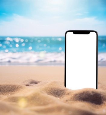 Akıllı telefon kumsalda gömülü duruyor ve arka plandaki kumsalın fotoğrafını çekiyor. Montaj ürünleri görüntüleme veya tasarım düzeni için kullanılabilir