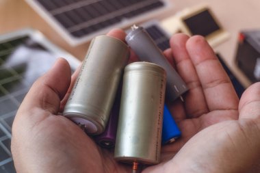 Arka planda Güneş Enerjisi Kurulumu ile El Tutma Çeşitli Şarj Bataryaları