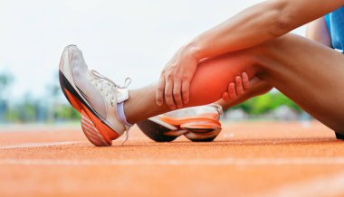 Koşu antrenmanı sırasında bacak sakatlığı ya da kramp nedeniyle buzağıya sarılan koşucunun yakın çekimi