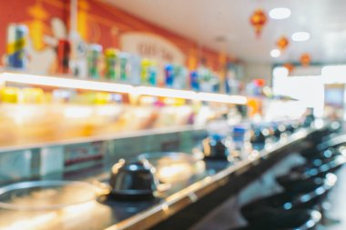 Mala Restoranı 'nın içini bulanık bir şekilde görüyorum. Konveyör bandı ve renkli yemekler geleneksel Asya yemek stili.