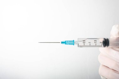 Elindeki şırıngayı kapat. Tıbbi enjeksiyon beyaza izole edildi. İlaç aşılama ekipmanları. Enjeksiyon için tüketim maddeleri, virüs koruması. Hastalıklar, tıbbi bakım. Uzayı kopyala Yüksek kalite fotoğraf