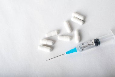 Şırınga ve haplar kapanıyor. Tıbbi enjeksiyon beyaza izole edildi. İlaç aşılama ekipmanları. Enjeksiyon için tüketim maddeleri, virüs koruması. Hastalıklar, tıbbi bakım. Uzayı kopyala Yüksek kalite fotoğraf