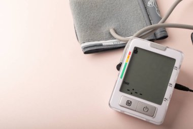 Tonometre yakın. Pembe arka planda kan basıncını ölçüyorum. Sağlık, hastalık tedavi konsepti ve sağlık kontrolü. Hipertansiyon ve tansiyon. Uzayı kopyala Pankart. Yüksek kalite fotoğraf