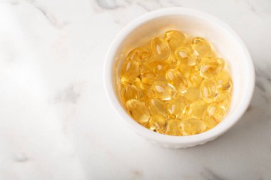 Mermer zemin üzerinde yumuşak kapsüllerdeki vitaminler. Omega 3 balık yağı, morina yağı yakın plan. Sağlık, takviye, D vitamini, hastalıkların tedavisi kavramı. Uzayı kopyala, afiş. Yüksek kalite fotoğraf