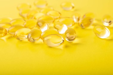 Sarı arka planda yumuşak kapsüllerdeki vitaminler. Omega 3 balık yağı, morina yağı yakın plan. Sağlık, takviye, D vitamini, hastalıkların tedavisi kavramı. Uzayı kopyala, afiş. Yüksek kalite fotoğraf