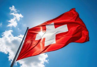 İsviçre 'nin ulusal bayrağı, beyaz haçlı kırmızı bir meydan, açık mavi gökyüzünün altında dalgalanır, dağınık beyaz bulutlar.