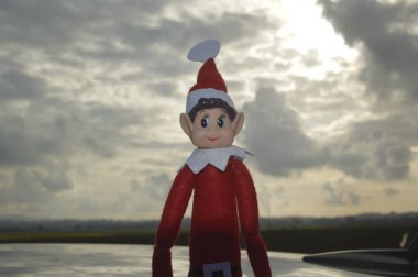 Arka planda bulutlar olan Noel elf bebeği