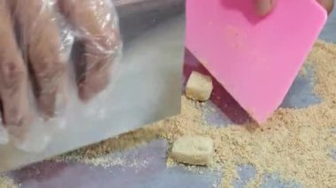 Kaloci küçük parçalara ayrılır, sonra fıstık tozu serpilir ve lezzetli bir karışım yaratmak için karıştırılır..