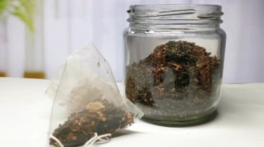 Aromatik ve aromalı gevrek yaprak çayı bir çay poşetiyle cam kavanozun içinde karışıyor. Rahatlatıcı ve ferahlatıcı bir içecek hazırlamak için mükemmel. Rahatlama anları için ideal..