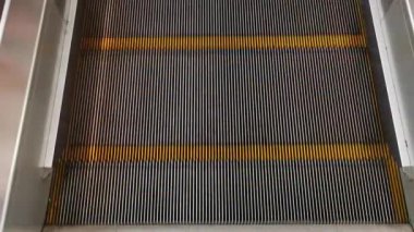 Yavaşça ilerleyen yürüyen merdiven basamaklarına yakın çekim. Kentsel ulaşım, modern mimari ve seyahat temaları için mükemmel..