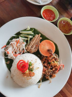 Vietnam mutfağının canlı tatlarını bu titizlikle sunulmuş Com Tam ile deneyin. Dokuların ve tatların ahenkli bir karışımı enfes bir aşçılık yolculuğu yaratır..