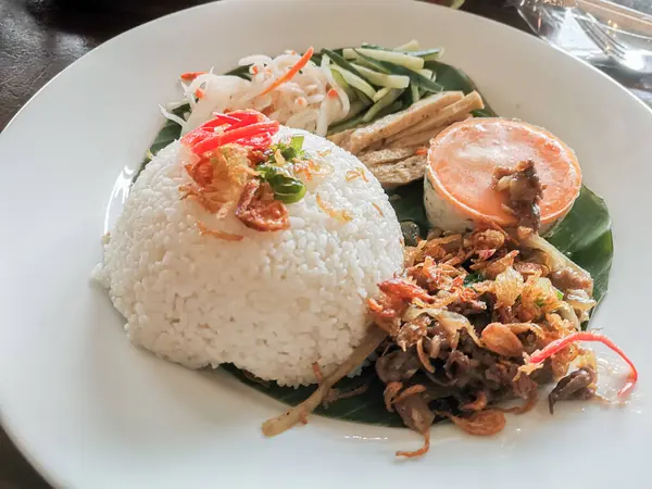 Viet Nam mutfağının iştah açıcı bir sunumu. Kırık pirincin yanı sıra çeşitli lezzetli mezeler de var. Görsel ve lezzetli bir yemek sunumu yaratıyor..