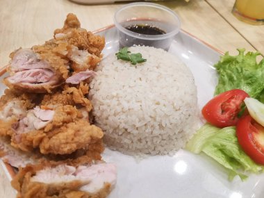 Lezzetli kızarmış tavuğun tadını çıkarın. Yumuşak pilav, tuzlu sos ve ferahlatıcı bir salata ile birlikte. Bu lezzetli yemek öğle veya akşam yemeği için mükemmel, lezzet dengesi sunuyor..