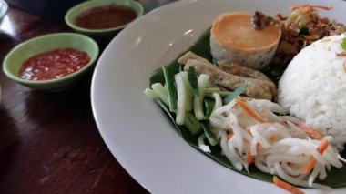 Explore this video showcasing Vietnamese broken  rice, a flavorful rice dish served with various side dishes. This Southeast Asian meal is full of vibrant colors and fresh ingredients.