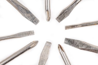 Düz beyaz arka planda çeşitli tornavida uçları ve boyutları var. Philips kafası ve farklı boyutlarda düz kafa..