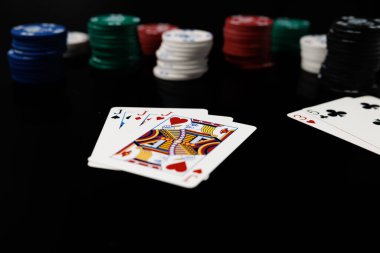 Poker kartları ve siyah arka planda kumarhane fişleri. Kart oyunu kumarı.