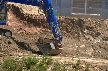 İnşaat alanında mavi kazıcı. İnşaat malzemeleri