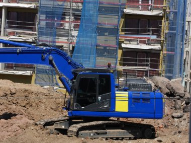 İnşaat alanında bir kazıcı. İnşaat malzemeleri. İnşaat